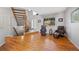 Sunlit living room with hardwood floors, staircase, and large window at 5706 S Garland Way, Littleton, CO 80123