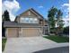 Lovely home with a three-car garage, stone accents, and a lush front lawn at 22302 Quail Run Way, Parker, CO 80138