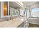 Elegant bathroom with double vanity, marble countertops, and a soaking tub at 6148 W Pacific Cir, Lakewood, CO 80227