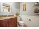 Powder room with granite countertop, wood cabinets, and white subway tile wainscoting at 6148 W Pacific Cir, Lakewood, CO 80227