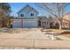 Two-story house with gray siding, two-car garage, and landscaped yard at 6148 W Pacific Cir, Lakewood, CO 80227