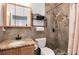 Updated bathroom featuring tiled shower and granite sink and a dark metal shelf at 6313 E 130Th Ave, Thornton, CO 80602