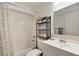 Clean bathroom featuring shower-tub combo, decorative mirror, and storage shelves for a functional and stylish space at 6313 E 130Th Ave, Thornton, CO 80602