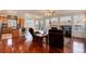 Open-concept living room featuring hardwood floors, fireplace, and seamless flow to the kitchen at 6313 E 130Th Ave, Thornton, CO 80602