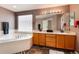 Main bathroom with double sinks, vanity, soaking tub, and ample natural light at 6313 E 130Th Ave, Thornton, CO 80602