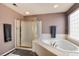 Main bathroom showcasing a shower, bathtub, and tiled floors with glass block window at 6313 E 130Th Ave, Thornton, CO 80602