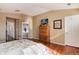 Main bedroom with wood floors, dresser, TV, ensuite bathroom, and natural light at 6313 E 130Th Ave, Thornton, CO 80602