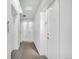 Well-lit condo hallway with gray carpet, white walls, and doors for easy access at 1300 N Ogden St # 304, Denver, CO 80218