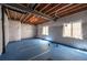 Unfinished basement with blue flooring and white insulated walls, offering potential for customization at 1358 14Th Ave, Longmont, CO 80501