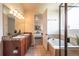 Bathroom featuring a double vanity, granite countertop, soaking tub and tile flooring at 1358 14Th Ave, Longmont, CO 80501