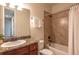 Bathroom with a granite countertop, tub and shower with tile surround, and brushed bronze fixtures at 1358 14Th Ave, Longmont, CO 80501