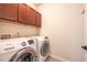 A laundry room area equipped with a Samsung washer and dryer and dark wooden cabinets for storage at 1358 14Th Ave, Longmont, CO 80501