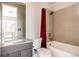 Bathroom featuring a sleek vanity and a combined shower and bathtub with a red curtain at 6021 N Boston Ct, Denver, CO 80238