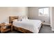 Bedroom with wood bed frame, neutral paint, and large window providing natural light at 6021 N Boston Ct, Denver, CO 80238
