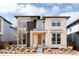 Modern home featuring stone accents, a stylish front door, and professionally landscaped front yard at 6021 N Boston Ct, Denver, CO 80238
