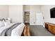 Spacious main bedroom showcasing a stylish bed, a natural wood bench, and bathroom access at 6021 N Boston Ct, Denver, CO 80238