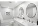 Elegant bathroom features double sinks, sleek fixtures, oval mirrors, and a shower/tub combo with modern tile at 2839 Ivanhoe St, Denver, CO 80207