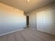 Spacious bedroom with neutral carpet and walls, and an attached closet at 48285 Shetland Dr, Bennett, CO 80102
