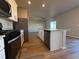 Modern kitchen with stainless steel appliances, a kitchen island, and hardwood flooring at 48285 Shetland Dr, Bennett, CO 80102