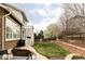 Manicured backyard featuring a stone patio, seating, a built-in grill, and green grass at 6103 S Millbrook Ct, Aurora, CO 80016