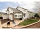 Landscaped backyard with stone patio, seating area, grass area, and deck with stairs at 6103 S Millbrook Ct, Aurora, CO 80016