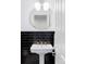 Powder room featuring black tile wall, pedestal sink, and gold fixtures at 6103 S Millbrook Ct, Aurora, CO 80016