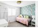 Charming bedroom with tropical-themed wallpaper, a twin bed, and natural light from the window at 6103 S Millbrook Ct, Aurora, CO 80016