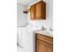 Functional laundry room with washer, dryer, sink, and wooden cabinets for storage at 6103 S Millbrook Ct, Aurora, CO 80016
