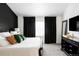 Well-lit primary bedroom with black accent wall, curtains, and dresser with mirror at 6103 S Millbrook Ct, Aurora, CO 80016