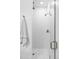 Modern tiled shower featuring a glass door, mosaic tile floor, and bronze fixtures at 6103 S Millbrook Ct, Aurora, CO 80016