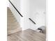 Carpeted staircase with dark handrail, white walls, and decorative lighting at 6103 S Millbrook Ct, Aurora, CO 80016
