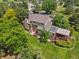 Aerial view showcases a charming home with a deck, lush green lawn and a mature tree line at 6895 S Norfolk St, Foxfield, CO 80016