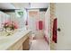 Charming bathroom featuring floral wallpaper, ample counter space, and bright light at 6895 S Norfolk St, Foxfield, CO 80016