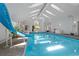 Bright indoor pool area featuring a slide, plenty of natural light, and ample space for recreation at 6895 S Norfolk St, Foxfield, CO 80016