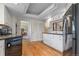 Well-lit kitchen with white cabinetry, hardwood floors, and black appliances at 6895 S Norfolk St, Foxfield, CO 80016