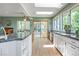Bright eat-in kitchen featuring granite counters, white cabinets, hardwood floors, and an adjacent breakfast nook with large windows at 6895 S Norfolk St, Foxfield, CO 80016