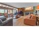 Spacious living room featuring hardwood floors, a stone fireplace, and plenty of natural light from large windows at 6895 S Norfolk St, Foxfield, CO 80016