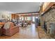 Spacious living room with a stone fireplace, built-in bookshelves, and large windows offering scenic views at 6895 S Norfolk St, Foxfield, CO 80016