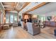 Bright and airy living room featuring wood beams, a stone fireplace, hardwood floors, and ample seating at 6895 S Norfolk St, Foxfield, CO 80016