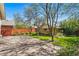 A lovely backyard with mature trees, green lawn, and a red fence surrounding the property at 810 Adams St, Denver, CO 80206