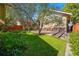 Beautifully landscaped backyard with mature trees, a well-maintained lawn, and a red fence at 810 Adams St, Denver, CO 80206