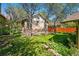 Serene backyard featuring lush green grass, mature trees, and a private red fence at 810 Adams St, Denver, CO 80206