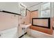 Retro pink bathroom with black accents features tub, tile, and vintage fixtures at 810 Adams St, Denver, CO 80206