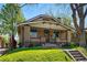 Charming brick home featuring a covered porch, manicured lawn, and easy access via concrete steps at 810 Adams St, Denver, CO 80206