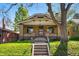 Charming brick home featuring a covered porch, manicured lawn, and easy access via concrete steps at 810 Adams St, Denver, CO 80206