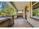 Spacious covered porch with brick railing, concrete flooring, and a hanging swing for relaxing at 810 Adams St, Denver, CO 80206