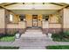 Welcoming front porch with decorative brick pillars, concrete steps, and green plants at 810 Adams St, Denver, CO 80206