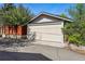 A large garage with a neutral-colored door, surrounded by greenery and a vibrant red fence at 810 Adams St, Denver, CO 80206