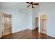 Bright bedroom featuring hardwood floors, ceiling fan, and ensuite bathroom and closet at 1436 Turnberry Dr, Castle Rock, CO 80104