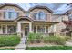 Townhome with a covered porch, decorative shutters, and manicured landscaping at 1436 Turnberry Dr, Castle Rock, CO 80104